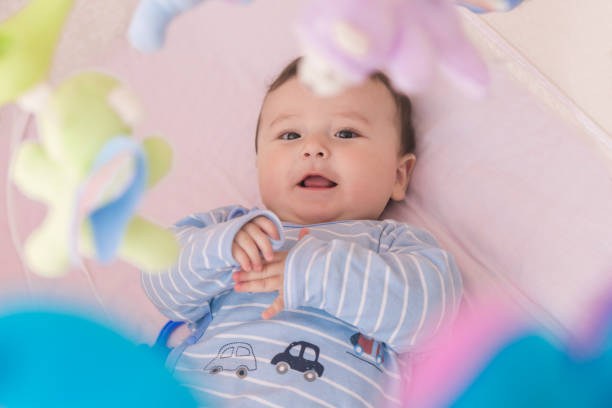 istock Happy baby lying in his crib smiling 664642824