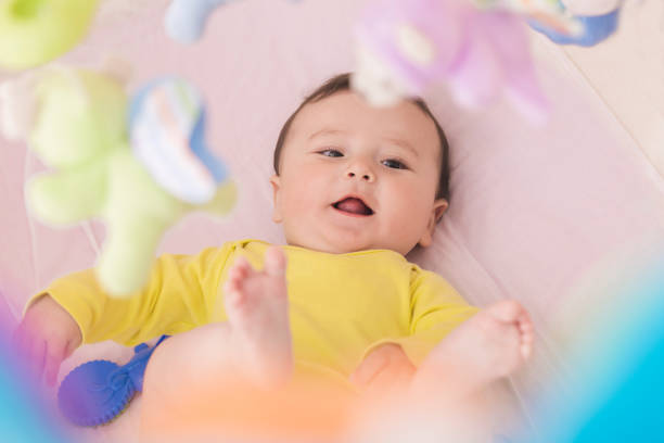 istock Happy baby lying in his crib smiling 664642844