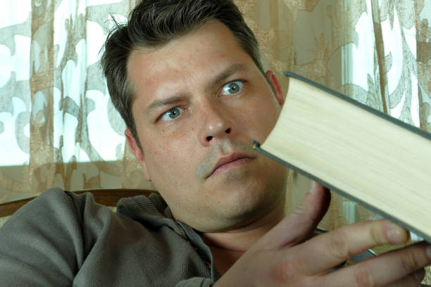 istock Young man reading a book in a chair 664663884