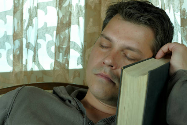 istock Young man reading a book in a chair 664663934