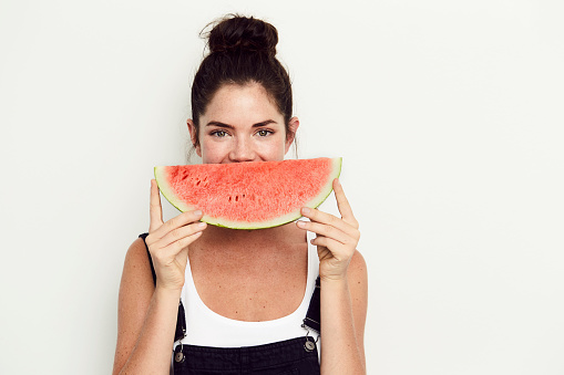 Grinning watermelon girl against white background