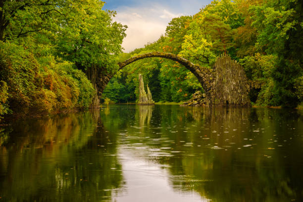 istock Autumn, cloudy evening over Devil's bridge in the park Kromlau, Germany 664669018