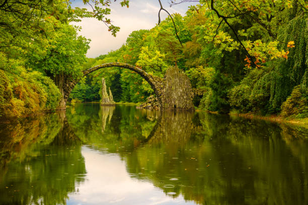 istock Autumn, cloudy evening over Devil's bridge in the park Kromlau, Germany 664669068