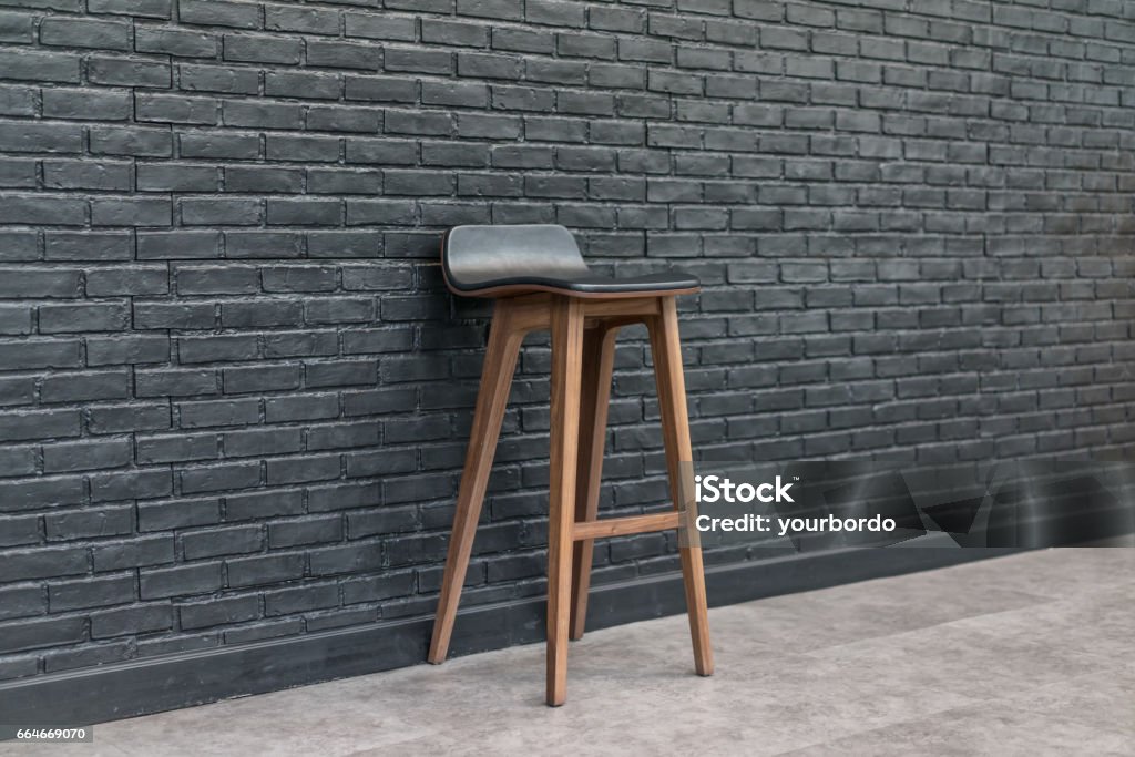 Bar chair. Wood and leather seat on brick wall background, design concept Cafe Stock Photo