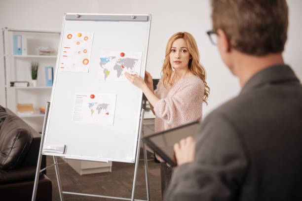 istock Shy young office manager defending project in the office 664673512