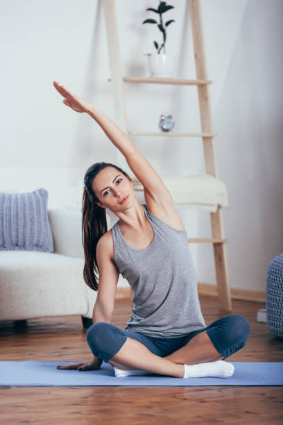 istock Young cheerful attractive woman practicing yoga, sitting in Sukhasana pose 664676272