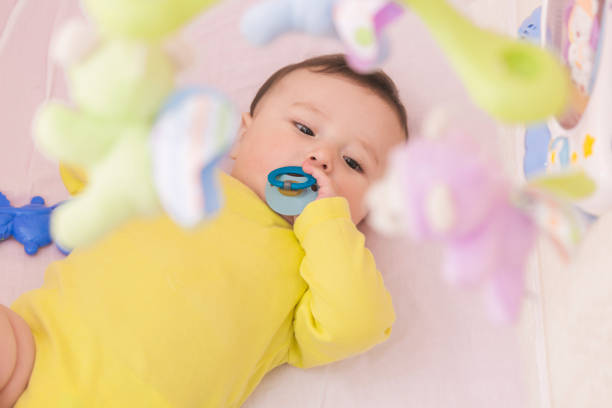 istock Happy baby lying in his crib sucking a pacifier 664677510