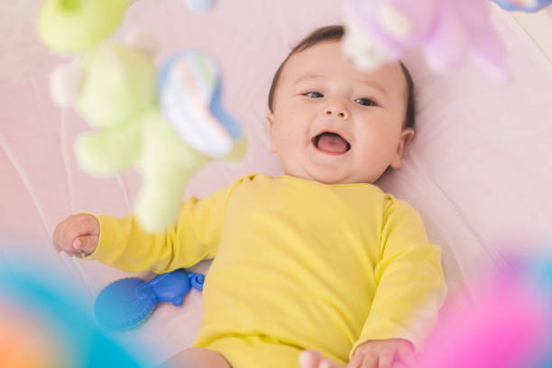 istock Happy baby lying in his crib smiling 664677516