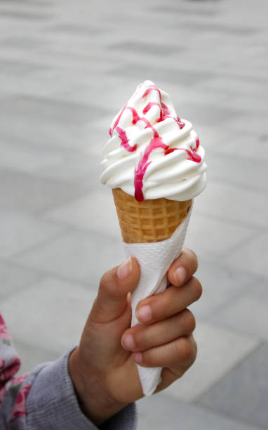 istock white ice cream cone with wafer in the hand 664679618