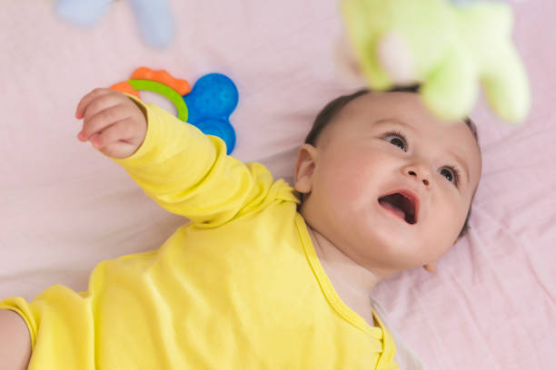istock Playful baby lying in his crib smiling 664679766