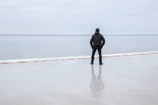 istock Man on the ice at the seashore feels the freedom. 664687232