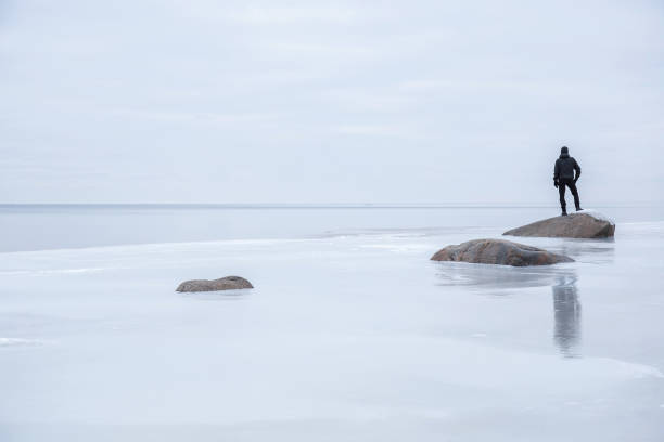 istock Man on the ice at the seashore feels the freedom. 664687356