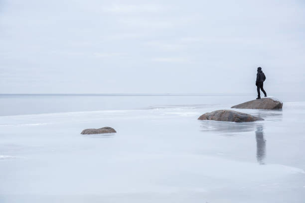 istock Man on the ice at the seashore feels the freedom. 664687382