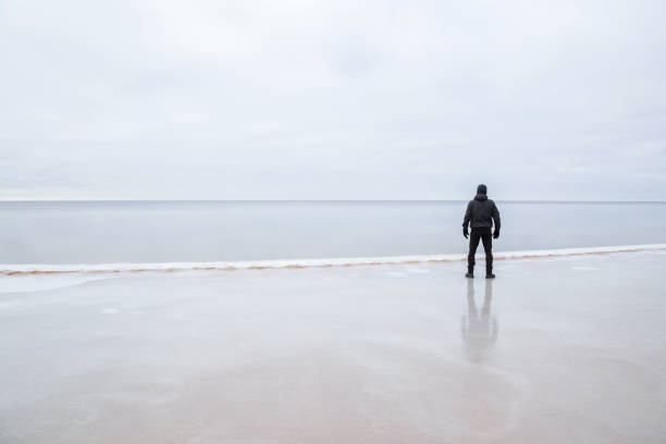 istock Man on the ice at the seashore feels the freedom. 664688036
