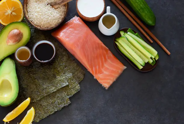 Photo of Ingredients for the preparation of rolls and sushi on a black background. food background