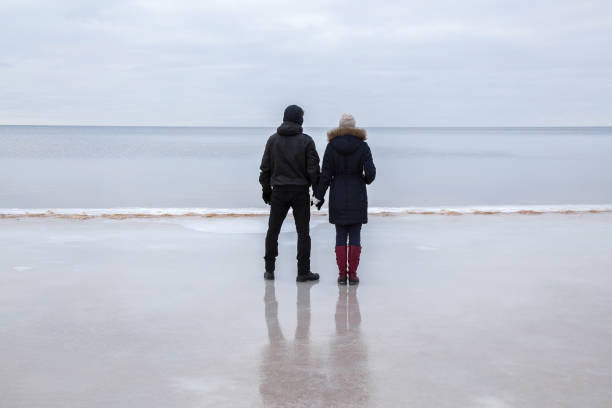 istock Young couple walking on the ice at the seashore. 664692088