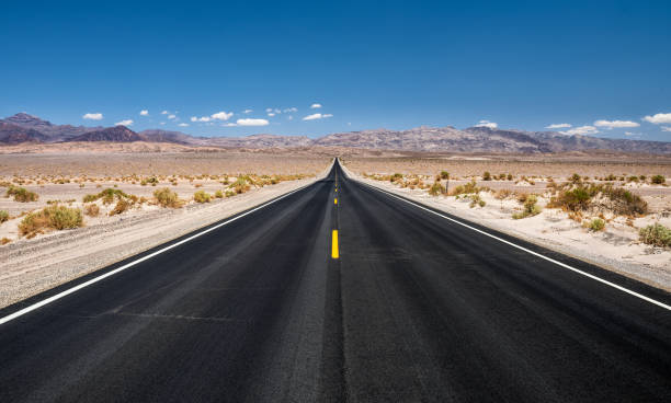 empty road running through  death valley national park - asphalt highway desert valley imagens e fotografias de stock