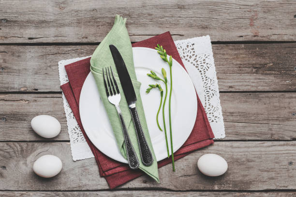 istock Top view of Easter table setting with cutlery, spring plant and Easter eggs on wooden table, Happy Easter concept 664692964