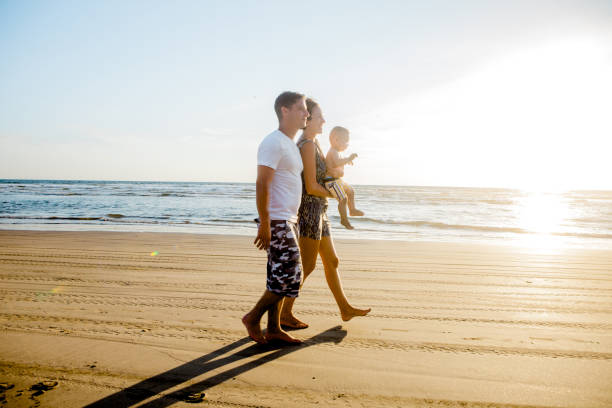 istock Family walking in the sea 664695432
