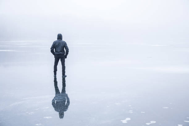 istock Man in the mist walking on the lake ice. 664696412