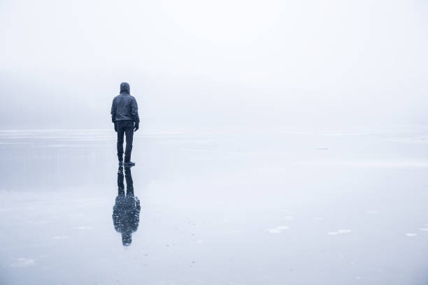 istock Man in the mist walking on the lake ice. 664696456