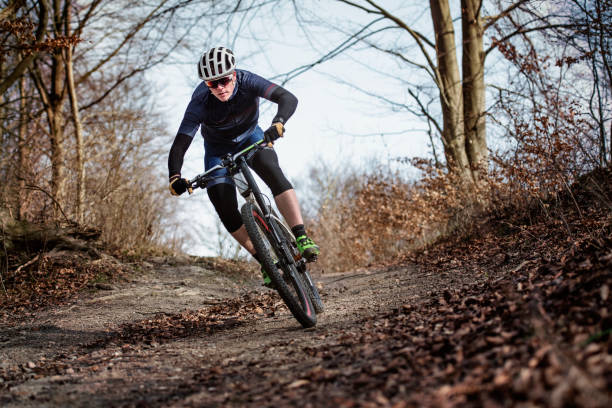 Portrait of Mountain Biker Out On a Training Ride Portrait of a male mountain biker out on a pretty intense training ride as he negotiates a trail through the woods.Taken in the early spring in the forests of Møns Klint on the island of Møn in Denmark. mountain biking stock pictures, royalty-free photos & images