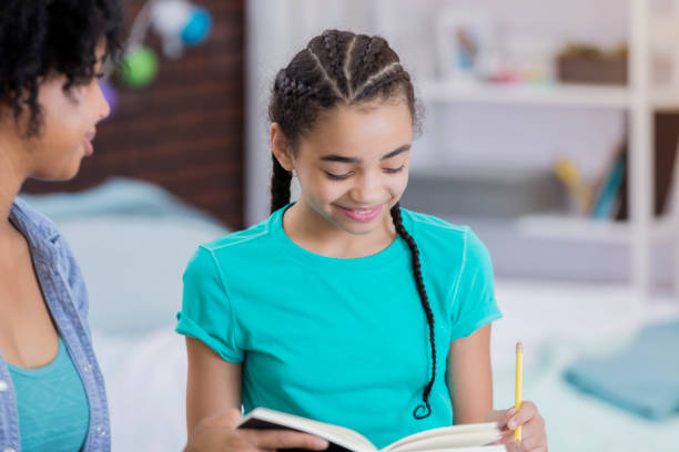 istock Tween girl reads book in her room 664698736