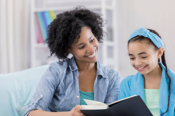 istock Mom and daughter read book together 664698968