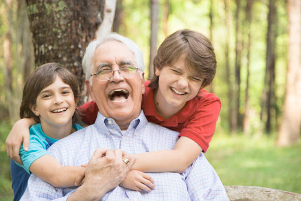 istock Grandfather and grandsons hugging outdoors together. 664706476