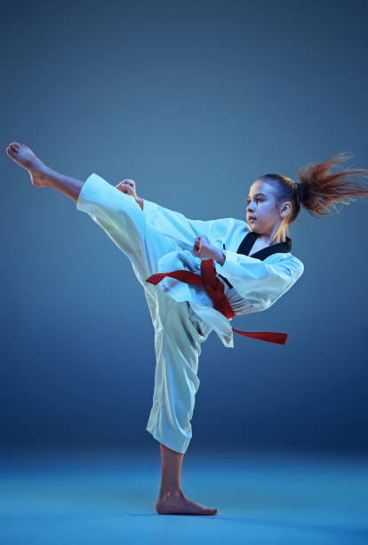 istock Young girl training karate on blue background 664706844
