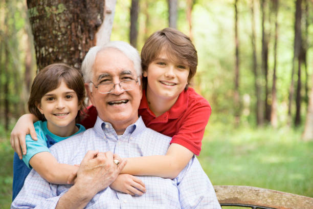 istock Grandfather and grandsons hugging outdoors together. 664708242