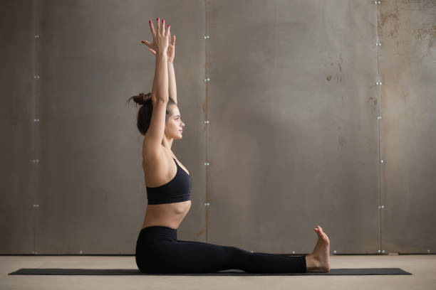 istock Young attractive woman sitting in Dandasana pose, grey studio ba 664715866