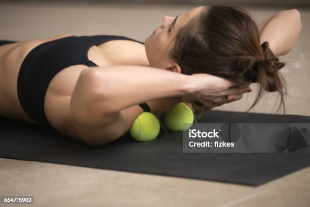 Young Sporty Woman Practicing Selfmassage Technique With Tennis Stock Photo - Download Image Now