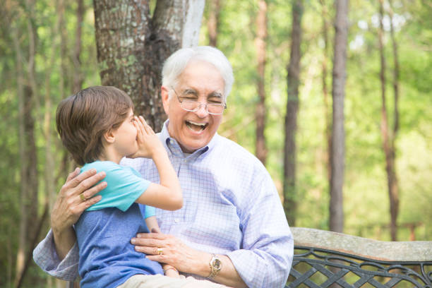 abuelo y nieto decir secretos al aire libre juntos. - whispering grandparent child grandfather fotografías e imágenes de stock