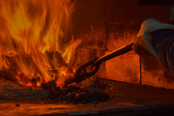 Coal forging flames Flames blaze brightly inside the dark coal forge as the blacksmith carefully guides the metal with tongs Furnace stock pictures, royalty-free photos & images