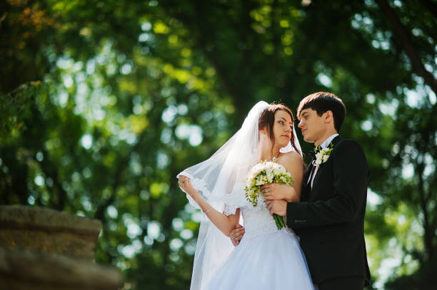 istock Young beautiful wedding couple at the park 664727888