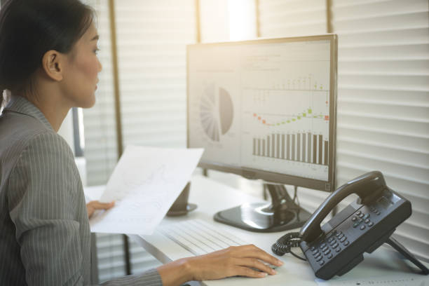 istock Business woman working in office with business graph on computer 664728092