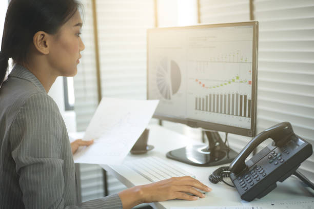 istock Business woman working in office with business graph on computer 664728104