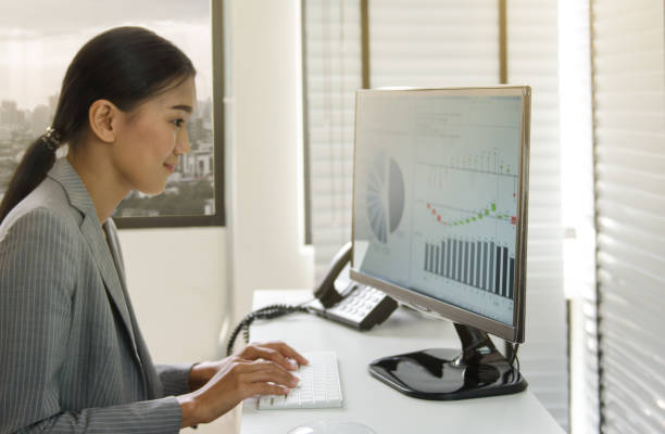 istock Business woman working in office with business graph on computer 664728138