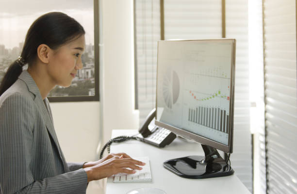 istock Business woman working in office with business graph on computer 664728148
