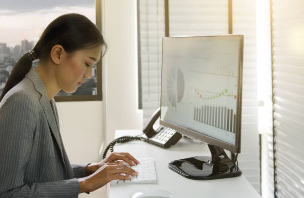 istock Business woman working in office with business graph on computer 664728150