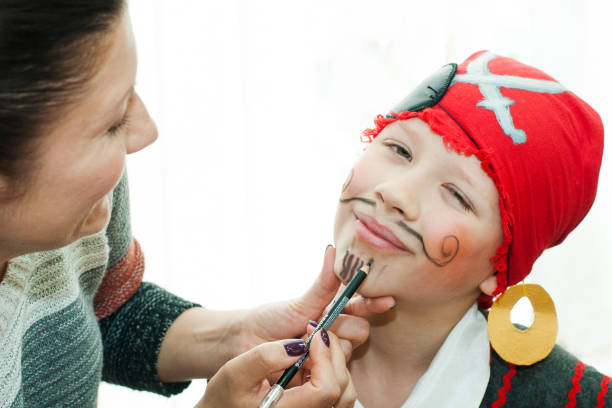istock woman paints the boy's face 664728278