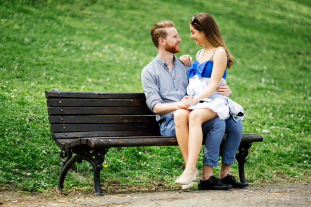 istock Couple in love spending time in nature on park bench 664728294