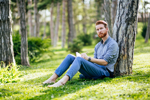 Handsome college student studying in park