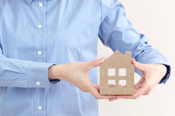 istock hand holding a wood house 664732552
