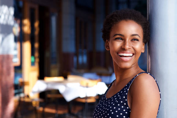 улыбаясь молодая черная женщина, стоящая снаружи - human head black women dress стоковые фото и изображения