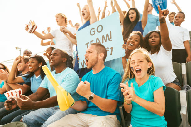 istock Crowd of fans cheering from stadium bleachers 664735410