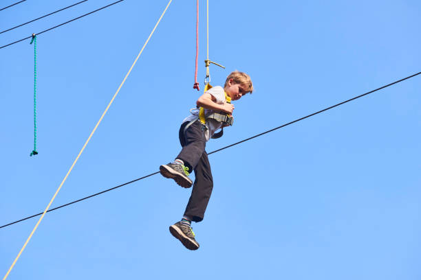 istock Cute school boy enjoying a sunny day in a climbing adventure activity park. 664738798