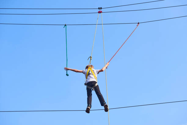 istock Cute school boy enjoying a sunny day in a climbing adventure activity park. 664738832