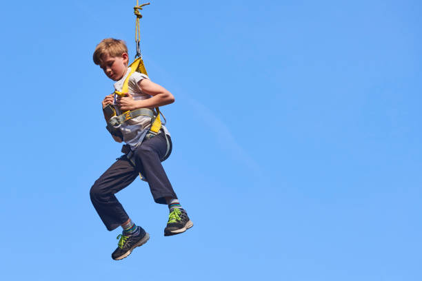 istock Cute school boy enjoying a sunny day in a climbing adventure activity park. 664738884